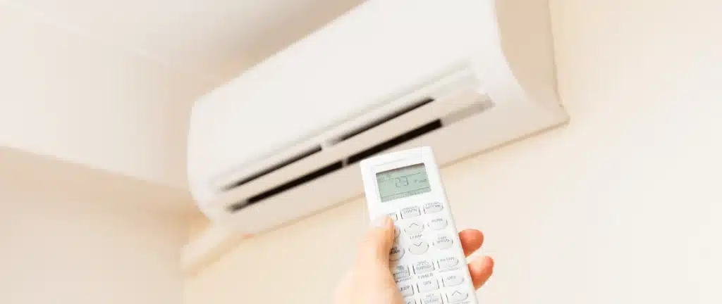 hand controlling air conditioning unit by pointing remote control to it 2